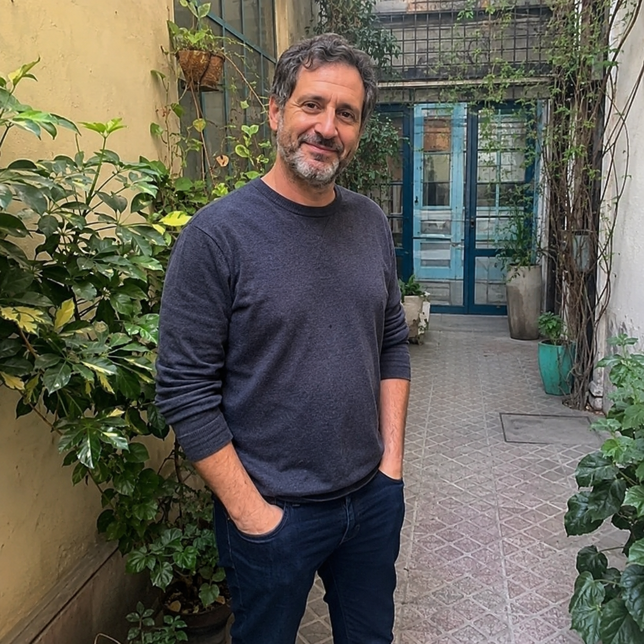 Mariano, alumno del programa, en un patio con plantas